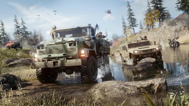Un camion militaire et un véhicule tout-terrain traversent une rivière, des parachutes dans le ciel, dans Call of Duty: Warzone
