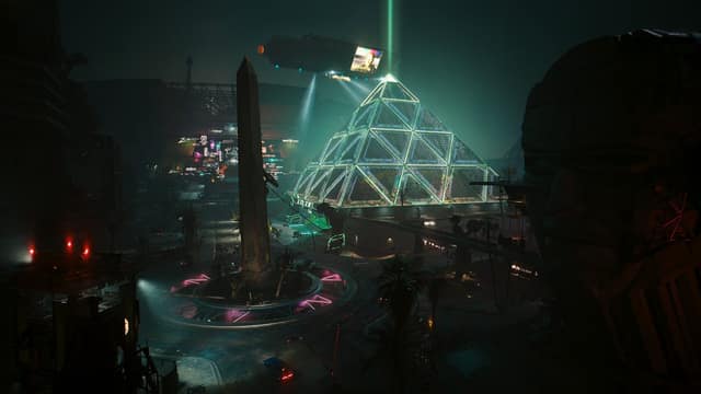 Une pyramide de verre illuminée et un obélisque dans le quartier de Dogtown, la nuit