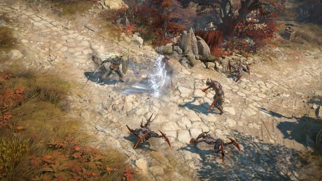 Un héros en armure frappe des créatures sur un chemin pavé bordé d'arbres rouges dans Diablo IV: Lord of Hatred