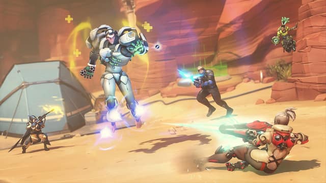 Plusieurs héros s'affrontent au pied de falaises rouges, l'un d'eux en lévitation, dans Overwatch