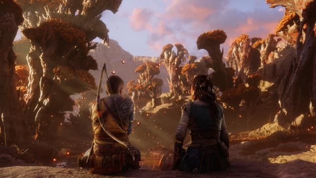 Atreus et une jeune femme assis de dos face à des arbres géants au coucher du soleil
