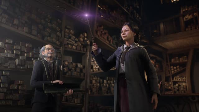 Une élève lève sa baguette lumineuse dans la boutique d'Ollivander, devant le marchand de baguettes