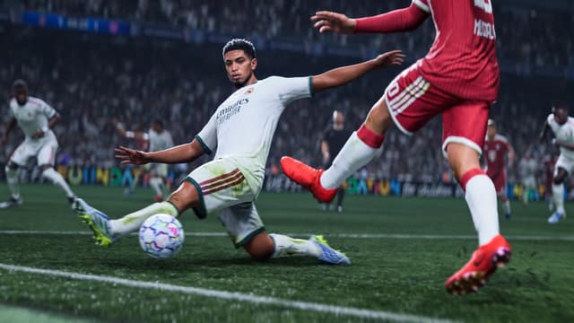 Un joueur du Real Madrid frappe le ballon en glissant devant un défenseur