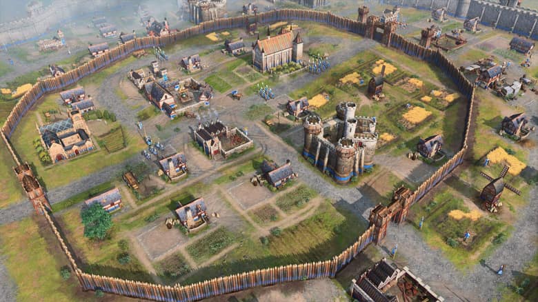 Age of Empires IV : une ville fortifiée vue de haut, entourée de sa palissade