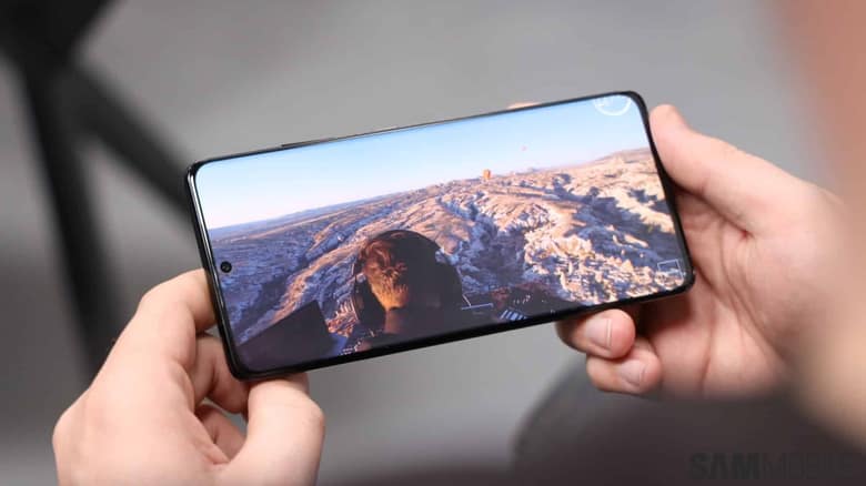 Un Samsung Galaxy S21 Ultra tenu à deux mains, affichant une photo de paysage