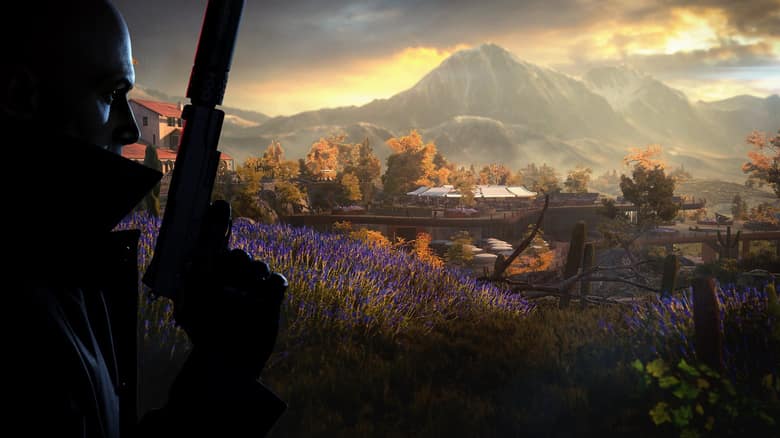 Hitman 3 : l'Agent 47 arme au poing devant un paysage de montagnes au lever du jour