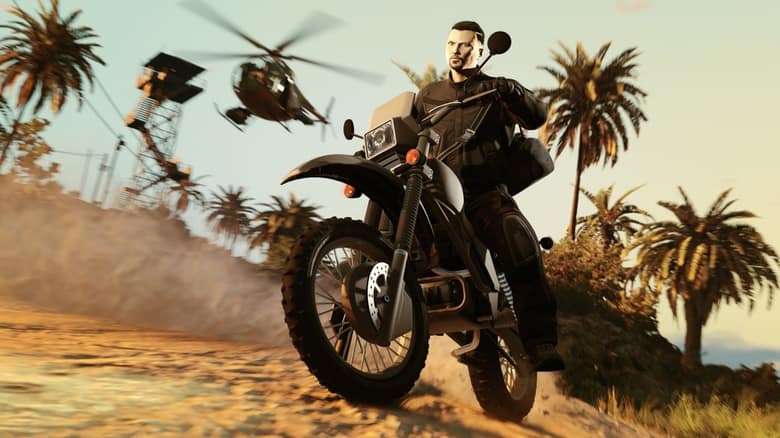 Un motard en tenue sombre sur une moto tout-terrain fonce sur une piste de sable, poursuivi par un hélicoptère militaire