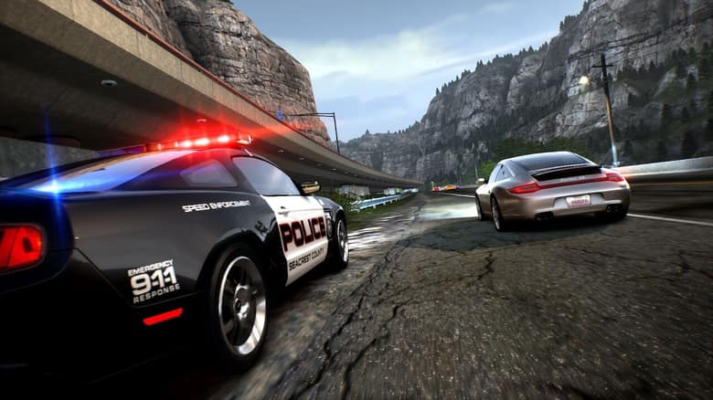 Une voiture de police noire et blanche poursuit une Porsche argentée sur une route de montagne