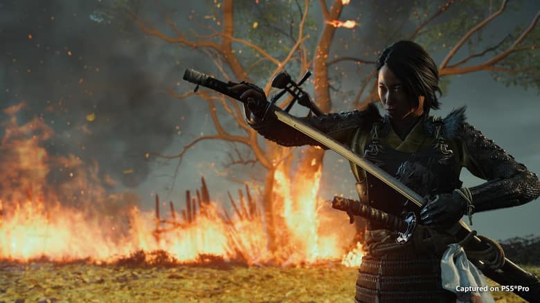 Atsu, katana à la main, devant un arbre en flammes dans un champ