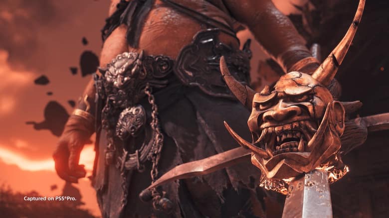 Un guerrier géant en armure derrière un masque d'oni posé sur une lame, sous un ciel rougeoyant