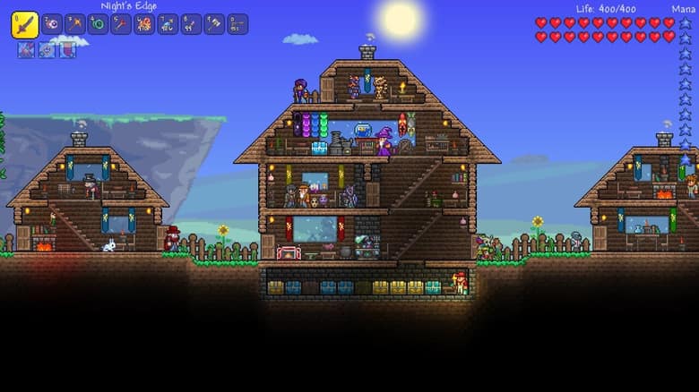 Village de Terraria en surface : plusieurs maisons en bois meublées et éclairées, habitées par des personnages non joueurs