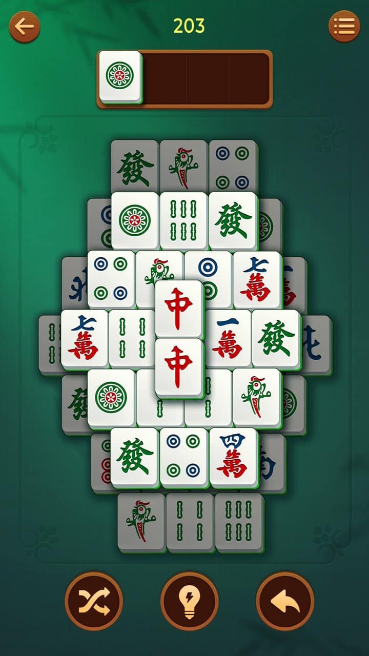 Plateau de Vita Mahjong sur téléphone : tuiles empilées, emplacement des tuiles choisies en haut, boutons de mélange, d'indice et d'annulation en bas