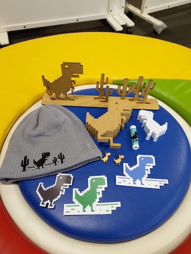 Objets à l'effigie du dinosaure de Chrome : bonnet, autocollants, figurines en bois et boucles d'oreilles