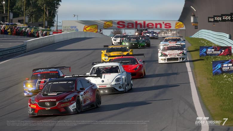 Une quinzaine de voitures de course, menées par une Mazda rouge, abordent un virage sur le circuit de Watkins Glen