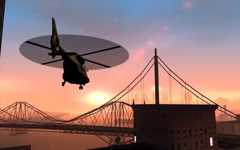 Un hélicoptère militaire survole les ponts de San Fierro au coucher du soleil dans GTA San Andreas