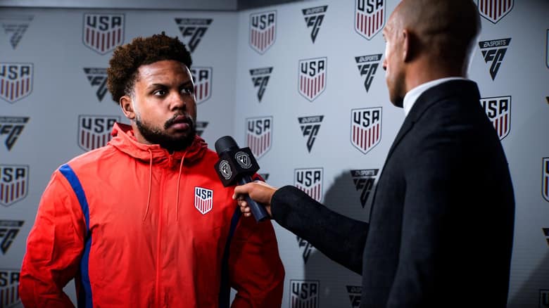 Un joueur de la sélection des États-Unis répond à un journaliste devant un panneau aux couleurs de sa fédération