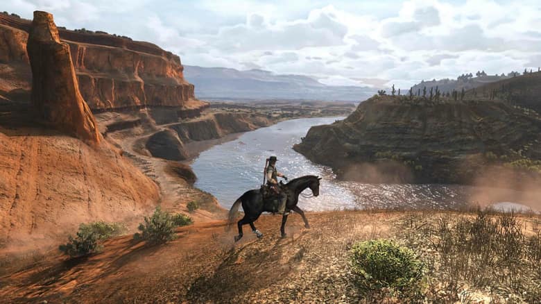 John Marston à cheval au bord d'un canyon rouge traversé par une rivière, dans Red Dead Redemption