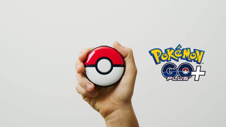 Une main tient le Pokémon GO Plus +, un boîtier rond rouge et blanc en forme de Poké Ball