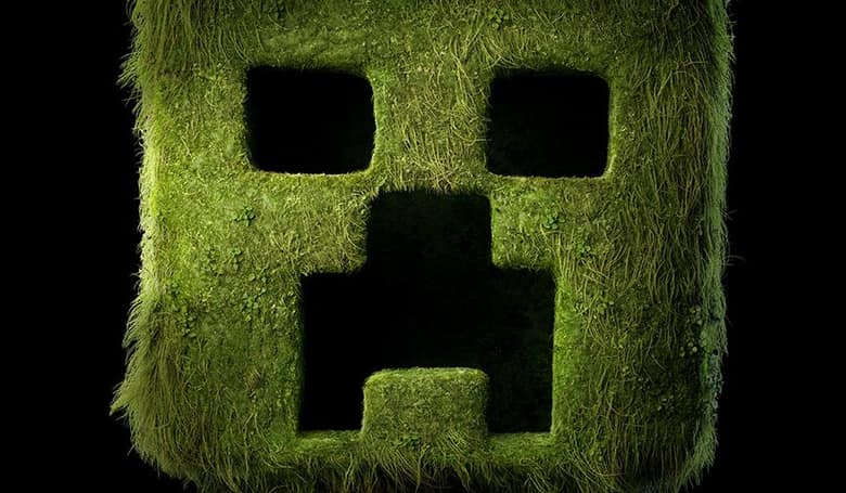 Une tête de Creeper géante recouverte d'herbe, sur fond noir