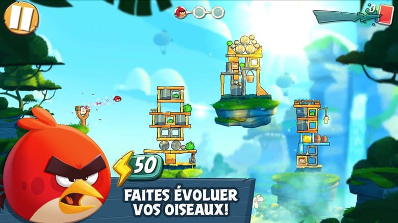Capture officielle d'Angry Birds 2 : Red au premier plan près de la fronde, devant des tours de cochons perchées sur des îles flottantes, avec le texte « Faites évoluer vos oiseaux ! »