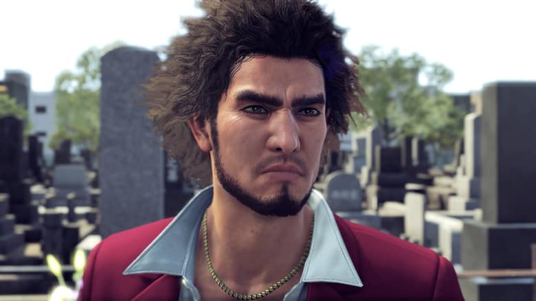 Capture officielle de Yakuza: Like a Dragon : gros plan sur Ichiban Kasuga, cheveux bouclés et veste rouge, dans un cimetière