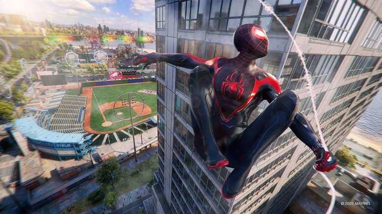 Miles Morales, en costume noir et rouge, accroché à la façade d'un immeuble au-dessus d'un stade de baseball