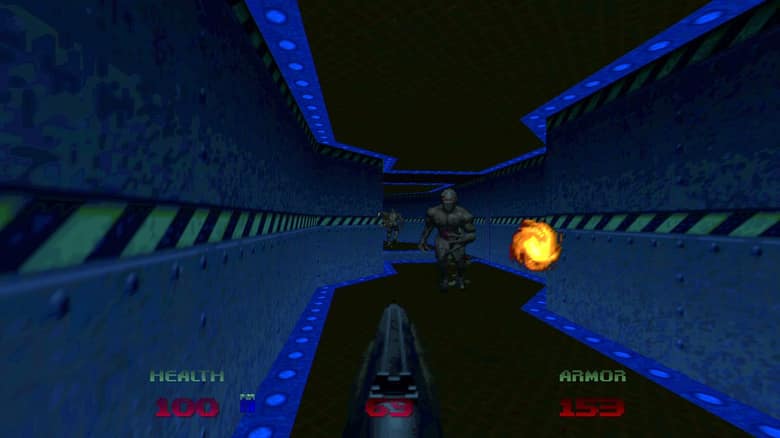 Couloir bleu métallique dans Doom 64, un démon approche au fond et une boule de feu fuse vers le joueur