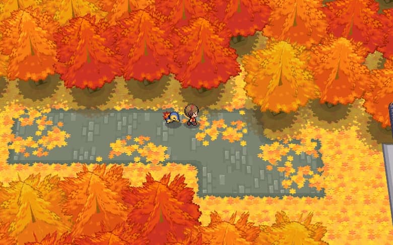 Un dresseur et son Héricendre sur un chemin pavé, au milieu d'arbres aux feuilles rouges et orangées