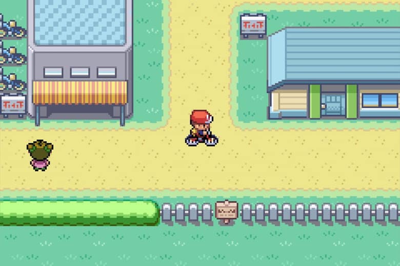 Le héros de Pokémon Version Rouge Feu à vélo dans une ville, capture officielle de la version Nintendo Switch